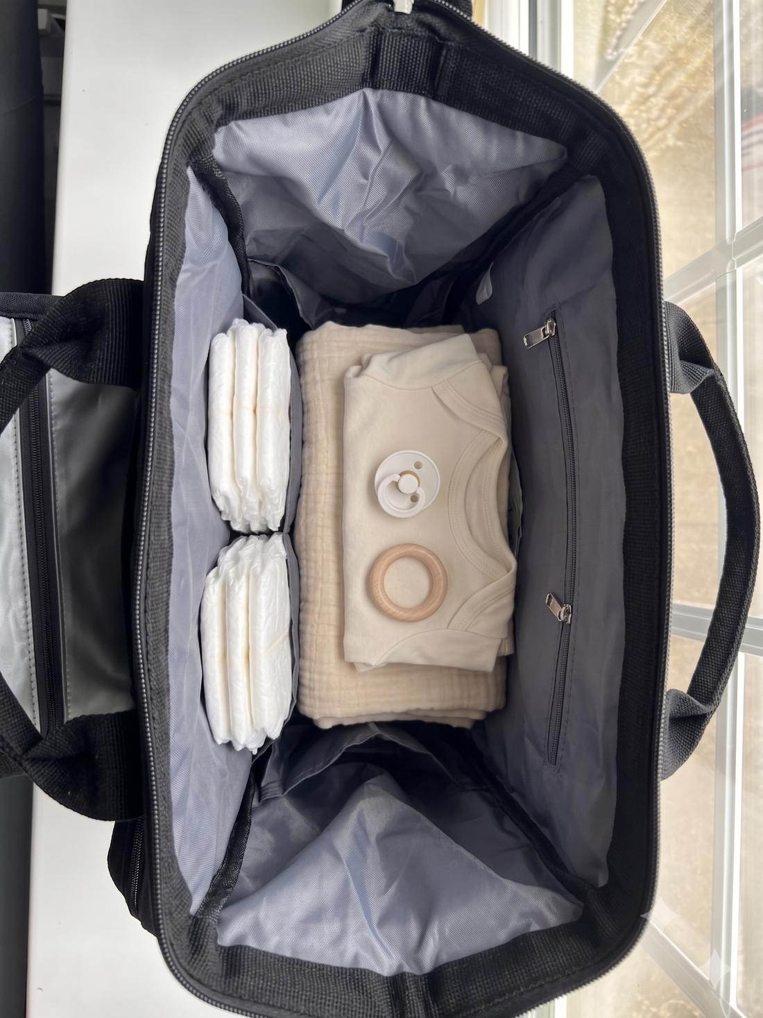 NestnGo changing bag main compartment wide open showing interior pockets — Charcoal Black