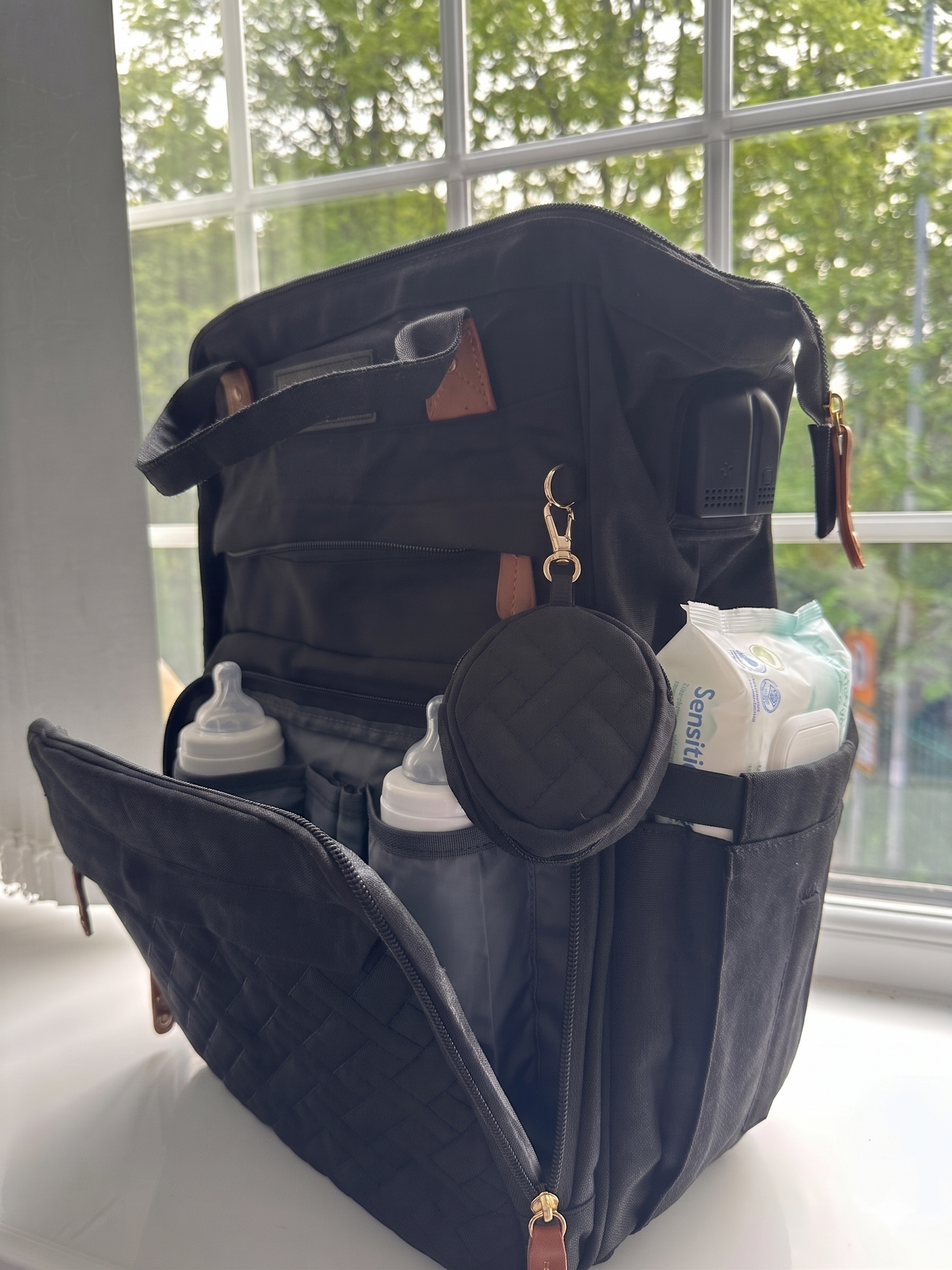 NestnGo nappy bag lifestyle — parent using bag at outdoor location with baby