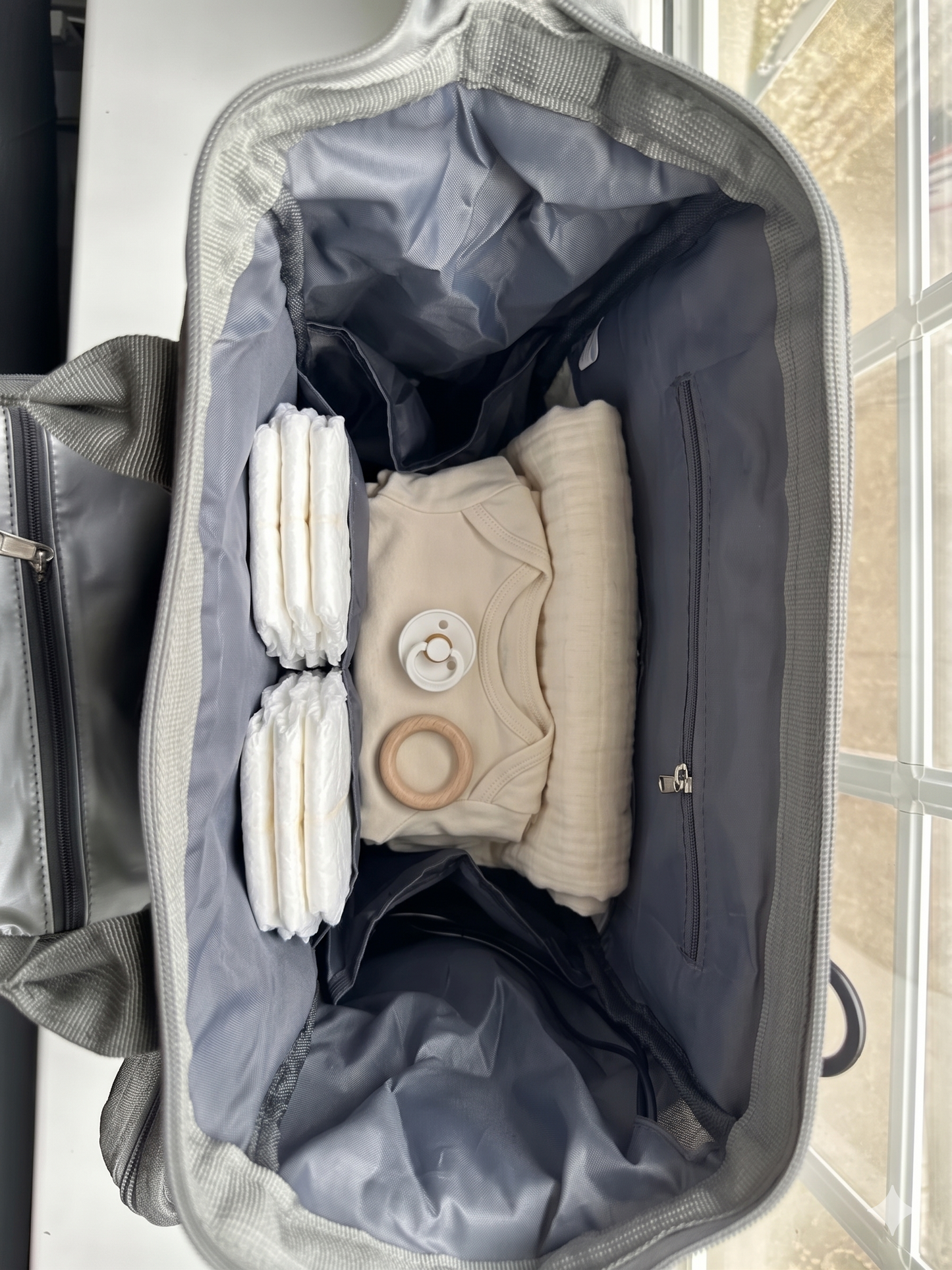NestnGo changing bag open showing wide main compartment with organised interior pockets