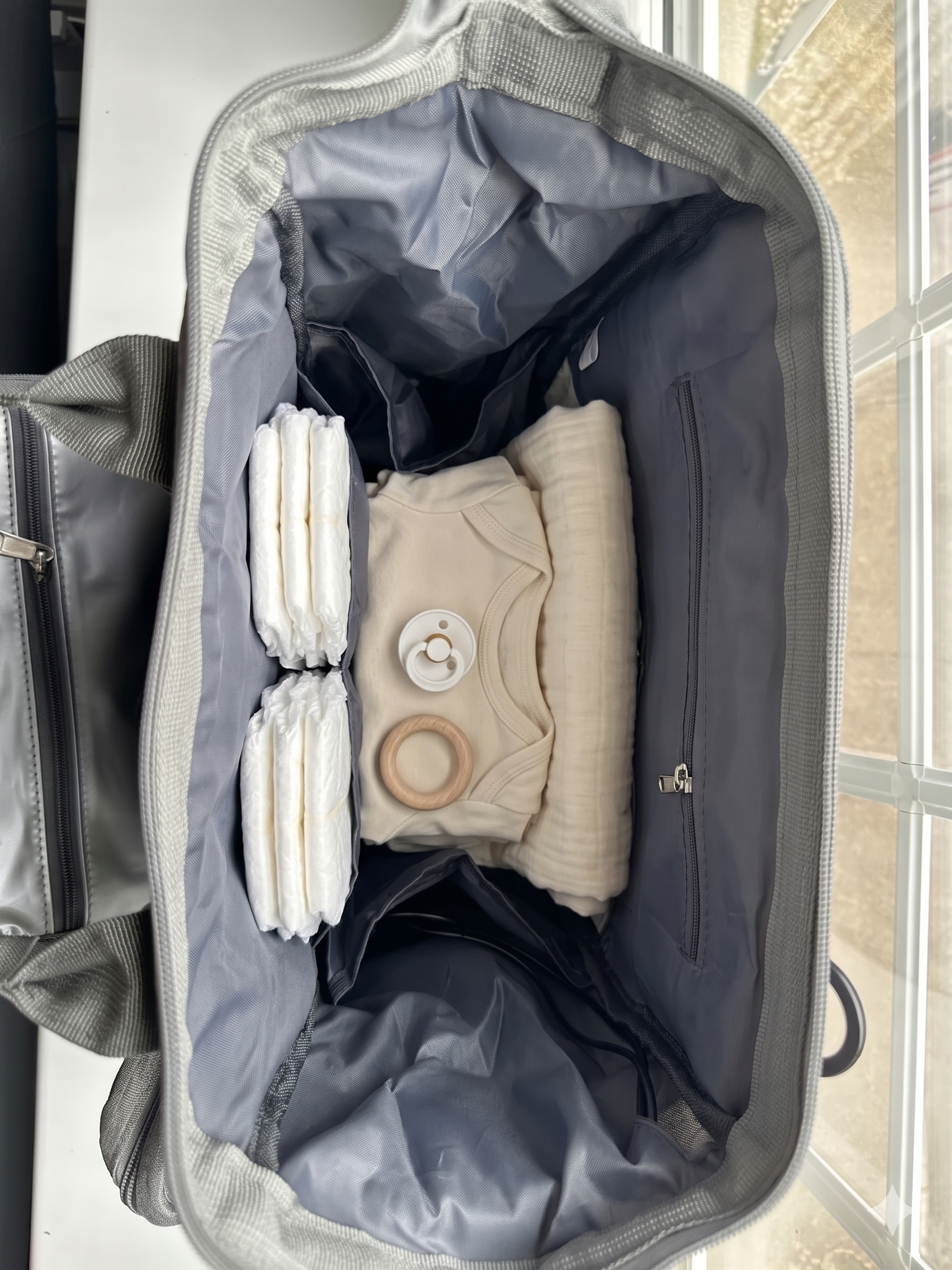 NestnGo changing bag open showing wide main compartment with organised interior pockets